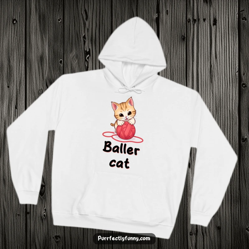Funny hoodie design of a cat leaping energetically to pounce on a rolling red yarn ball, captured in a moment of pure playfulness.