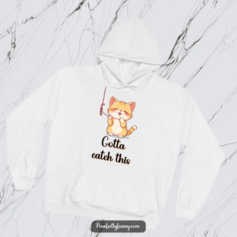 Funny hoodie depicting a cat deeply engaged in batting at a dangling string, cozy and amusing.