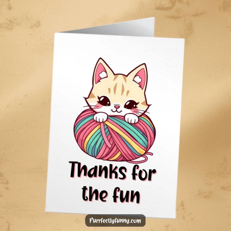 Funny Free Printable Thank You Card: A cat with a mischievous grin peeking out from behind a colorful ball of yarn.