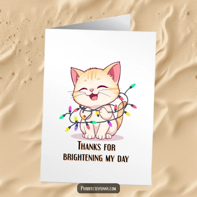 Funny Free Printable Thank You Card: A cat looks adorably delighted, tangled in colorful lights, offering a unique and funny thanks.