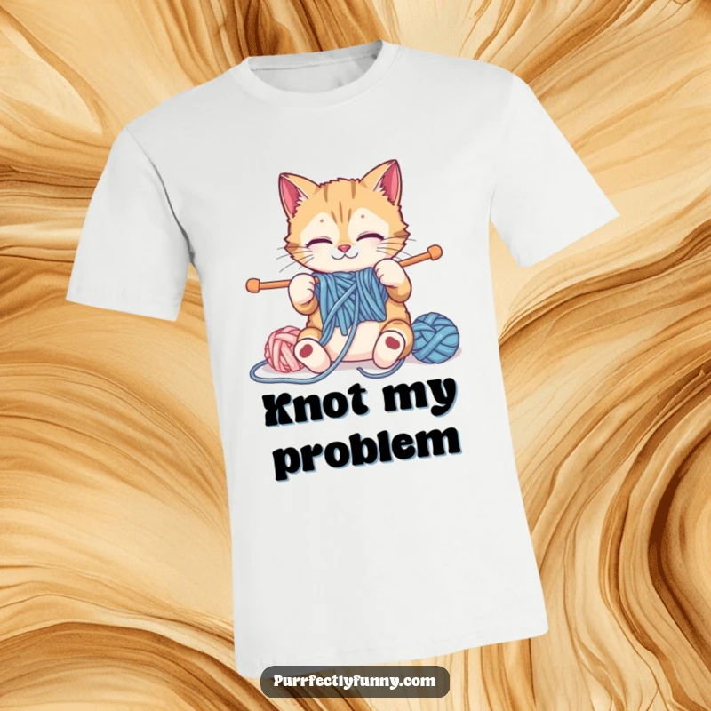 Funny cat attempting to knit with comically large yarn and needles, on a humorous and comfortable funny t-shirt.