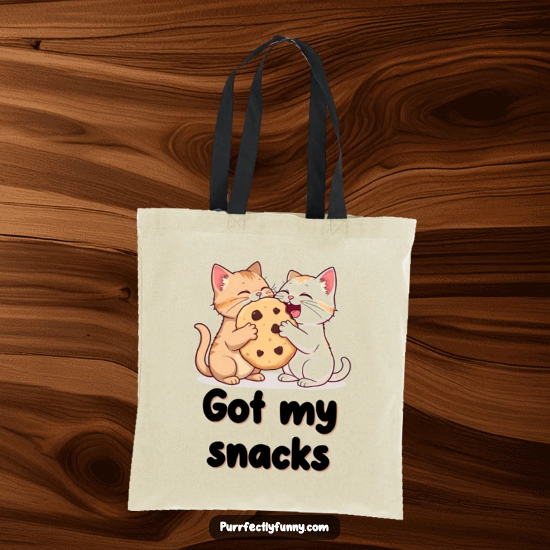 Funny tote bag design of two cats amicably sharing an oversized cookie, a humorous and practical accessory.